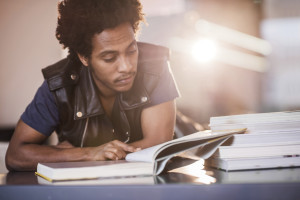 African American student studying while sitting in the library.