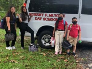 Guerrero children standing near school bus